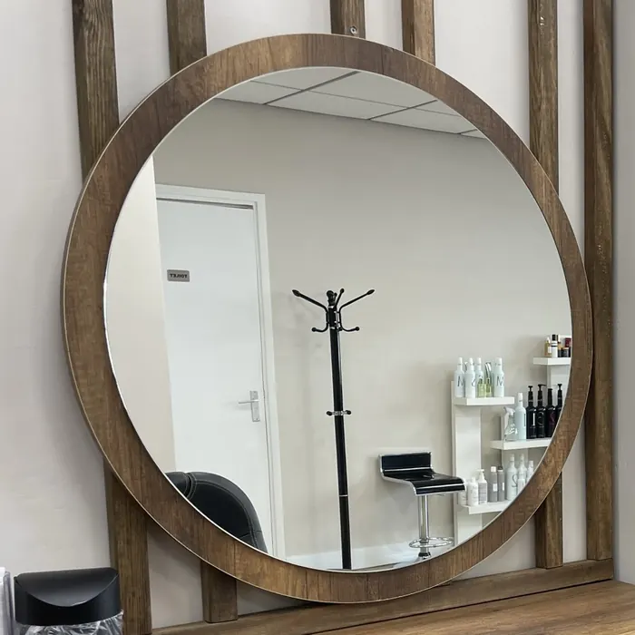 Ronde spiegel met houten lijst in de salon aan de Kanaalstraat